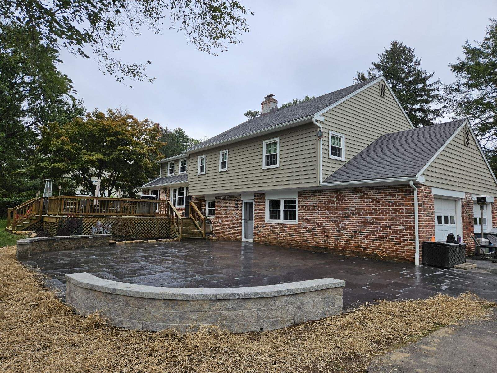 freshly finished stone patio behind a brick house with short walls bordering the corners