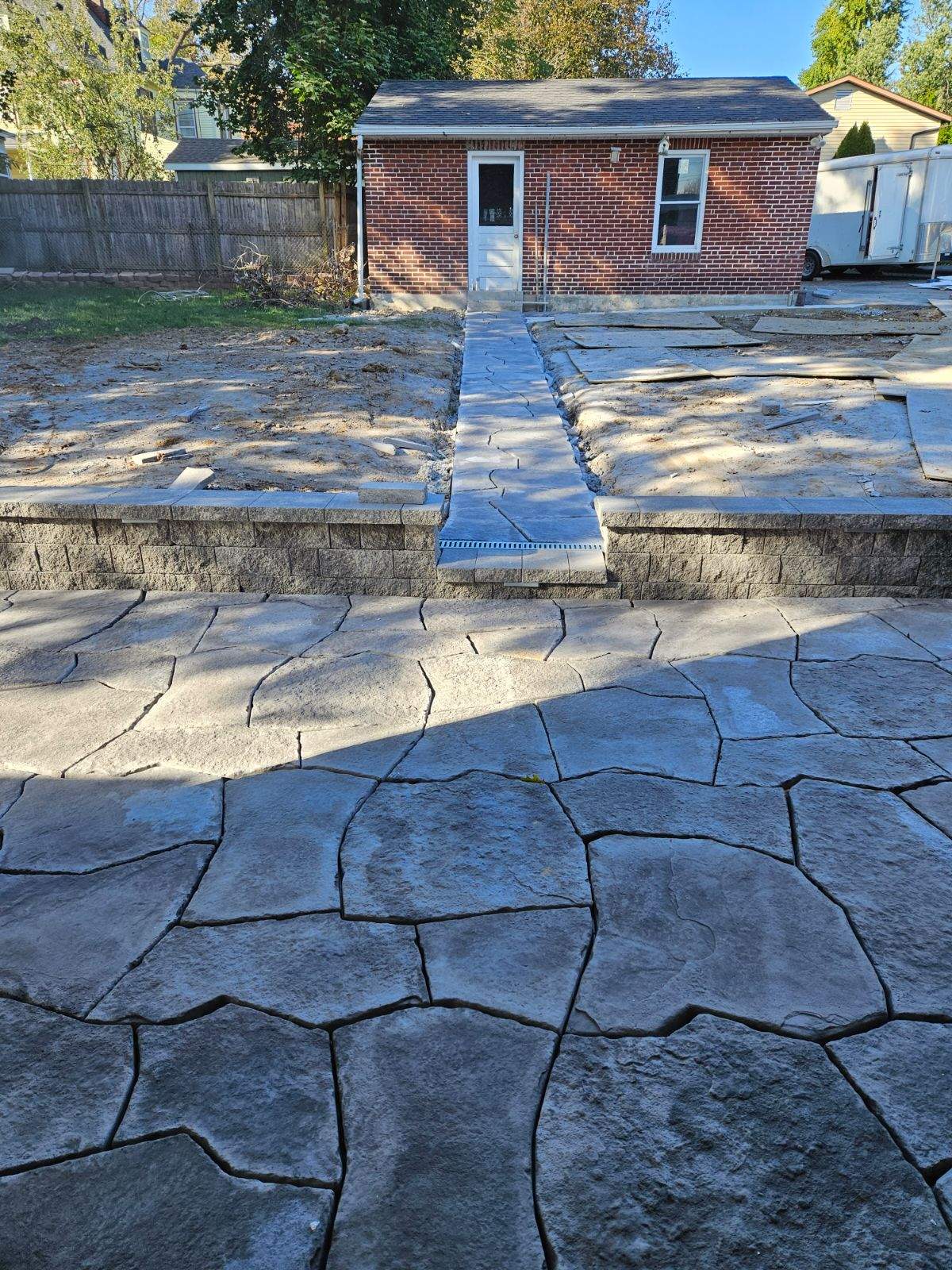 stone patio with walls leads to stone walkway to the shed